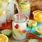 pitcher of lemonade pouring into a glass with citrus fruit